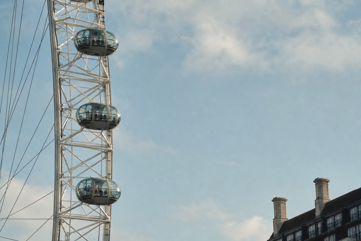 A row of London Eye capsules evenly spaced against a pale sky